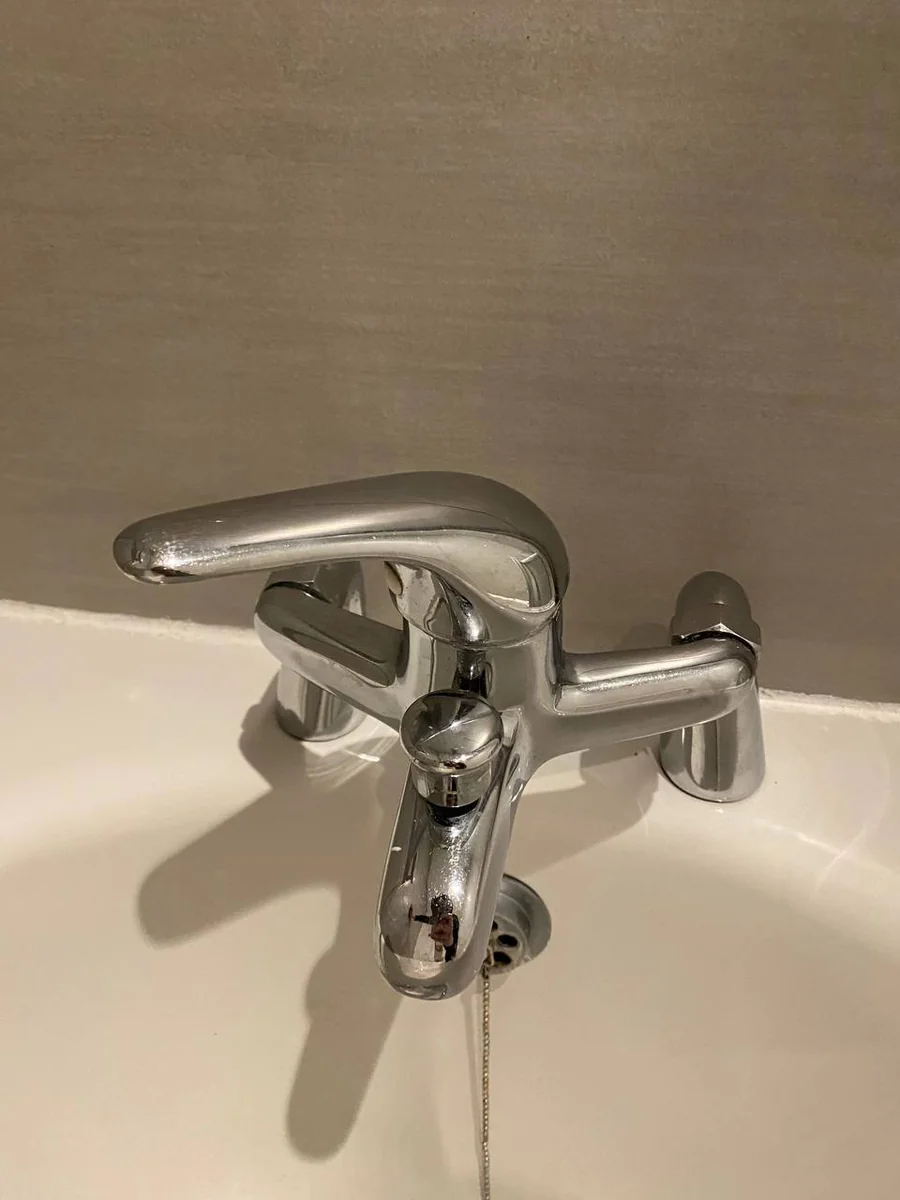 Chrome bath tap shining after limescale removal in a London bathroom