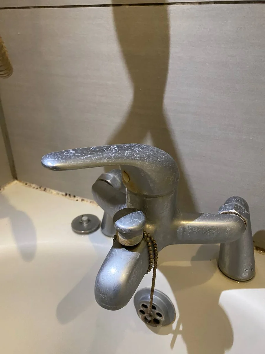 Chrome bath tap coated in limescale before an eco-friendly bathroom clean