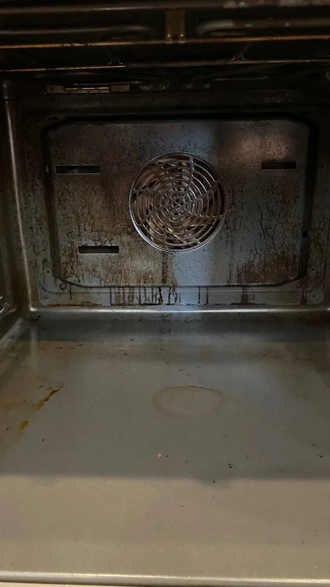 Oven interior with baked-on grease and burnt food before oven cleaning