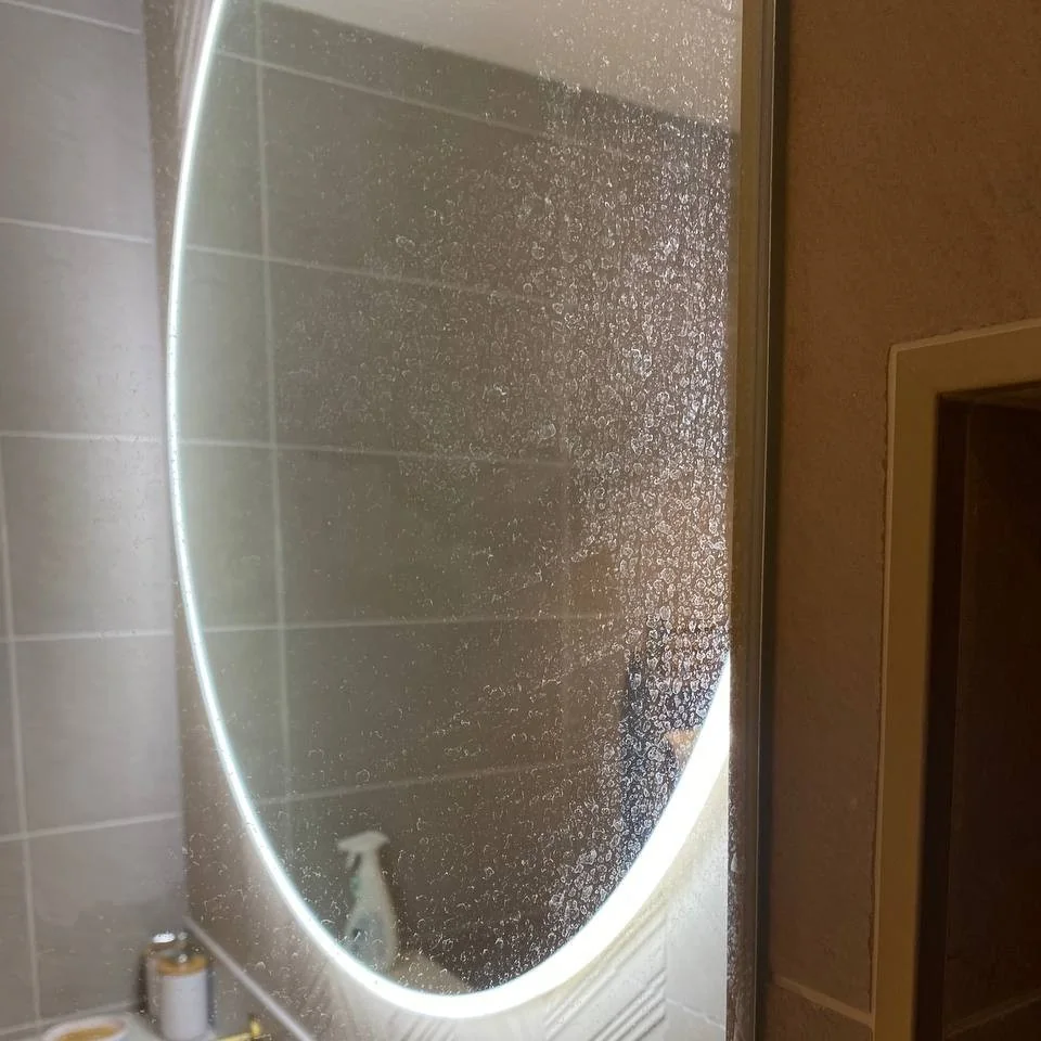 Bathroom mirror covered in limescale and water spots before cleaning