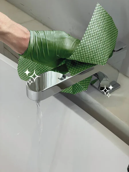 Cleaner polishing a bathroom tap with a reusable eco cleaning cloth